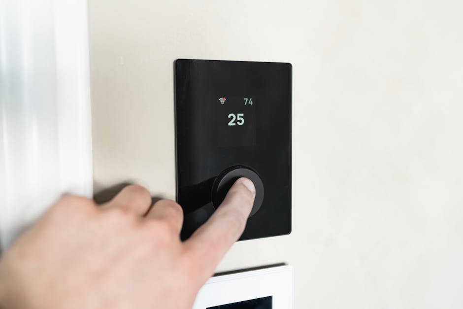 Adjusting a modern smart thermostat on the wall